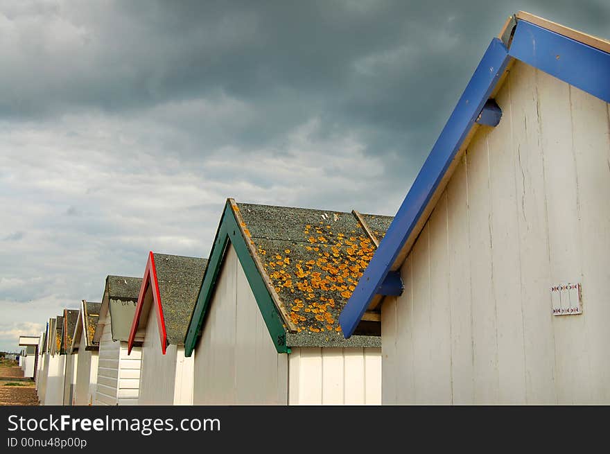 Line of beach hut roofs on a cloudy day