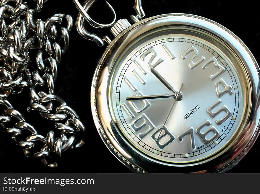 A silver pocket watch captured close-up. A silver pocket watch captured close-up