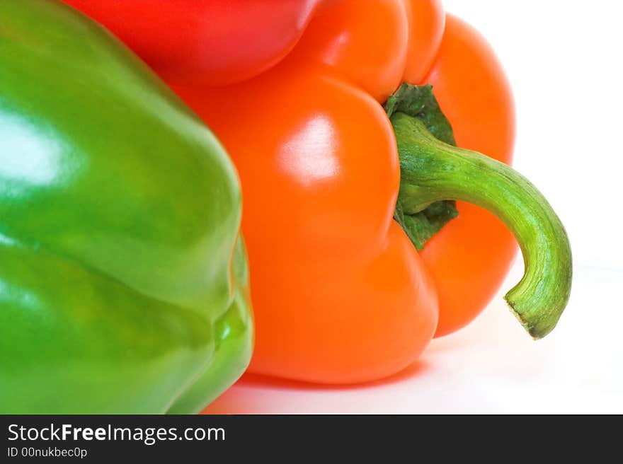 Closeup detail of shiny fresh bell peppers; red green and orange.