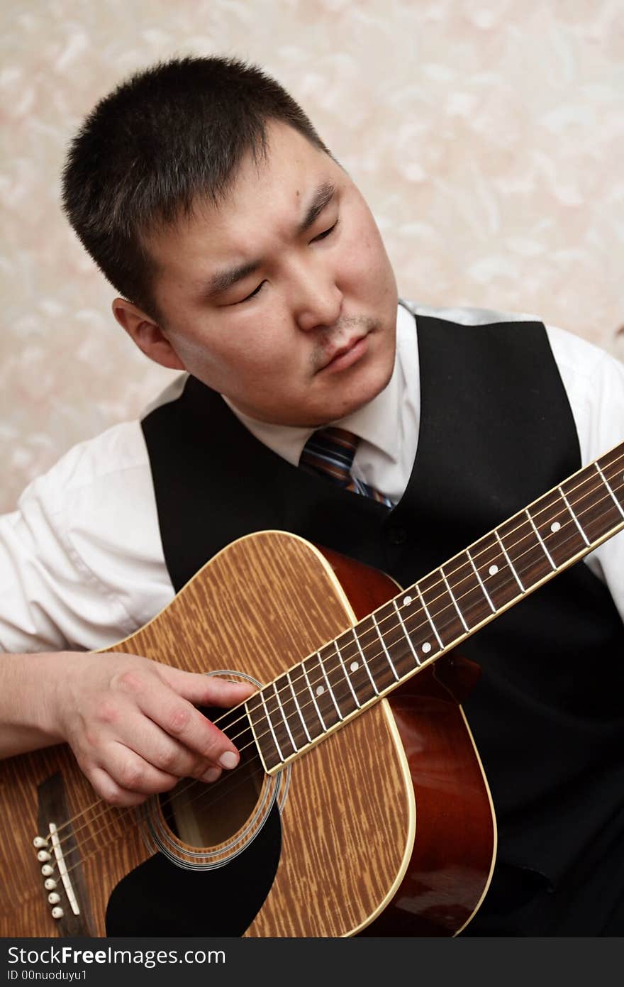 The man playing the guitar at home. The man playing the guitar at home