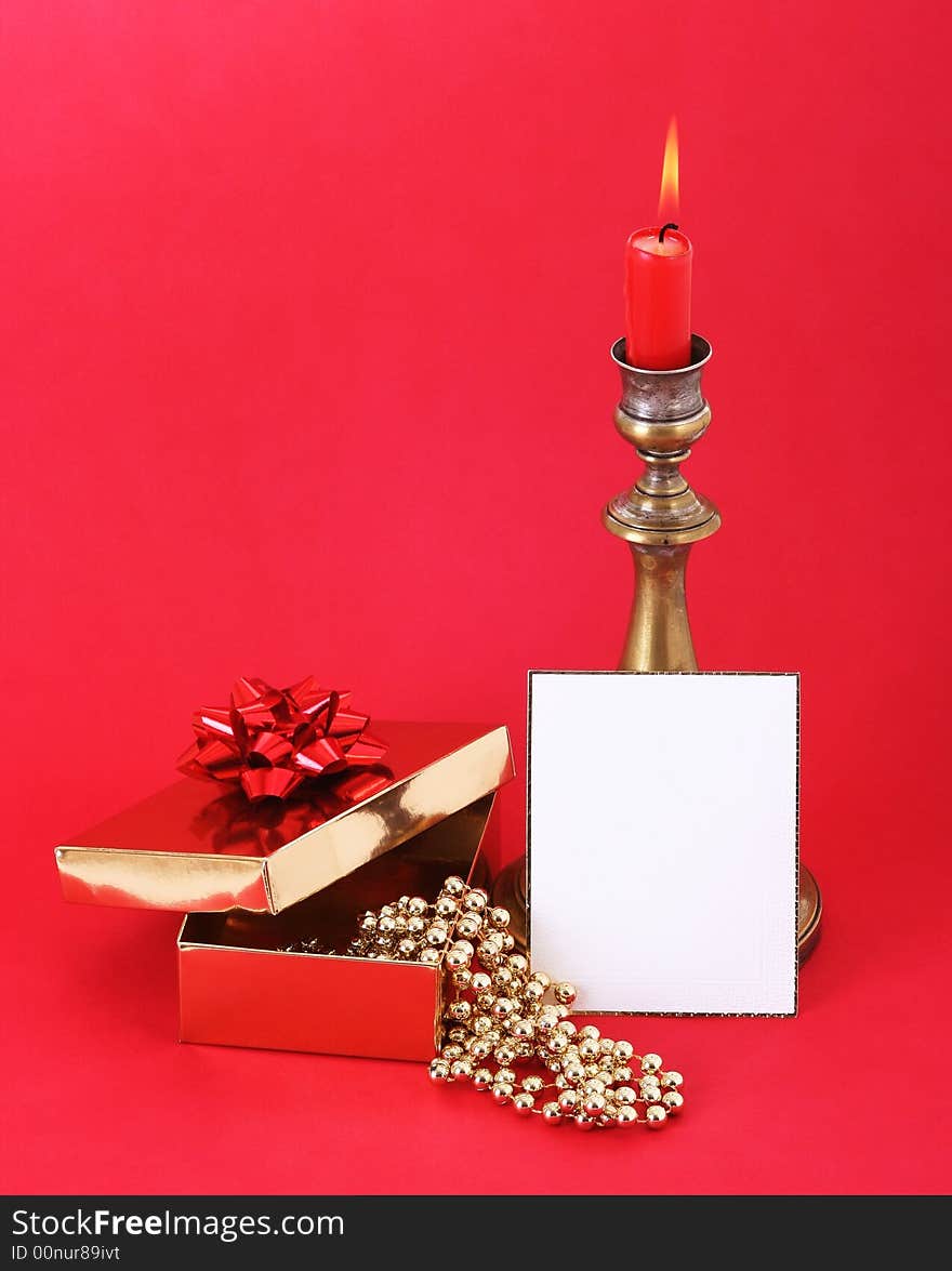 Christmas candle with flame. A white card in front. Red background. Christmas candle with flame. A white card in front. Red background.