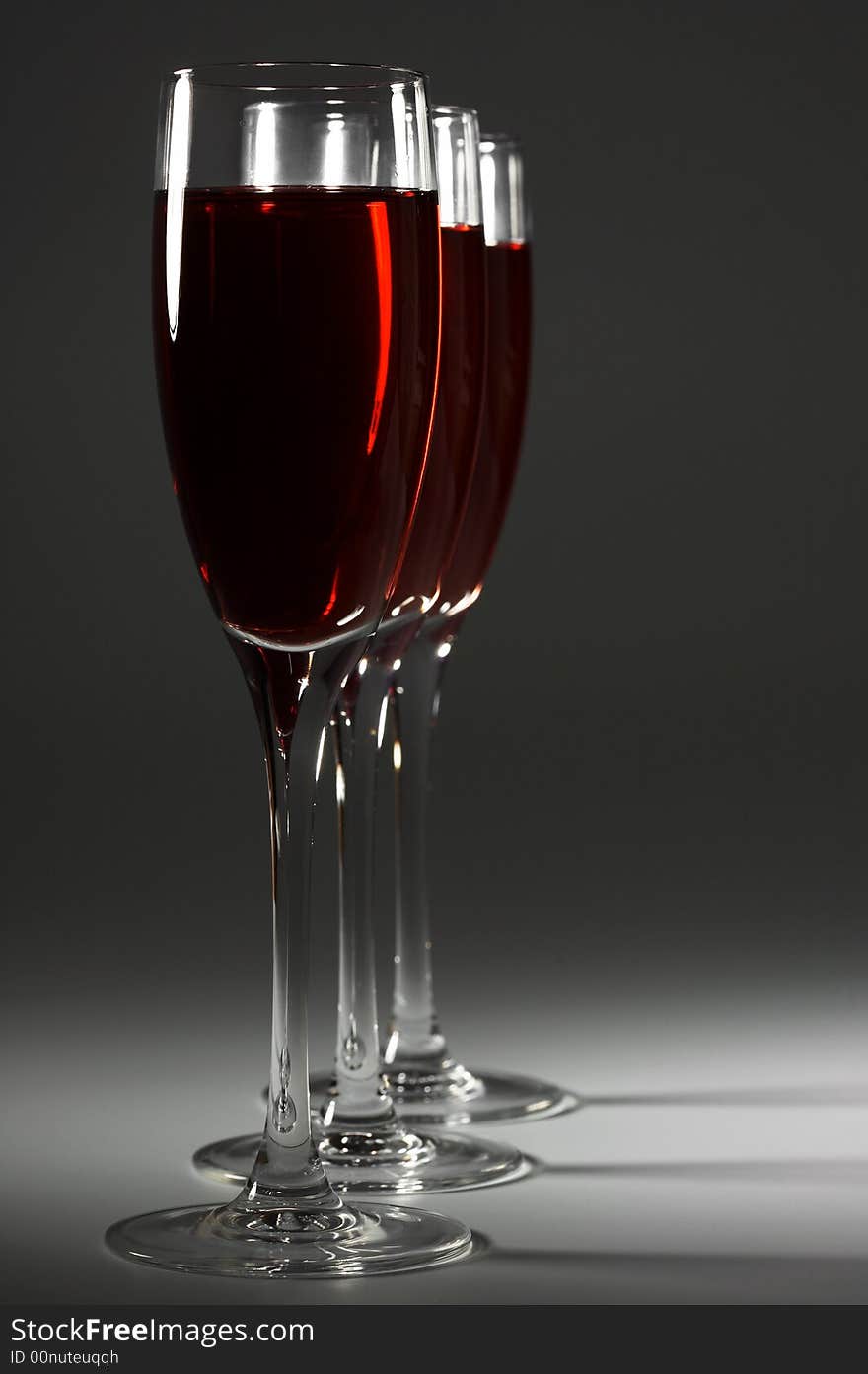 Three glasses with red wine on a dark background