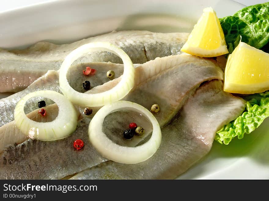 Arranged herrings with onion rings and lemon