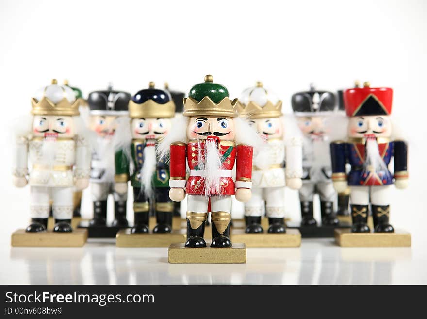 A whimsical group of holiday nutcrackers isolated on a white background. Shallow DoF with focus on front nutcracker. Holiday concept. A whimsical group of holiday nutcrackers isolated on a white background. Shallow DoF with focus on front nutcracker. Holiday concept.