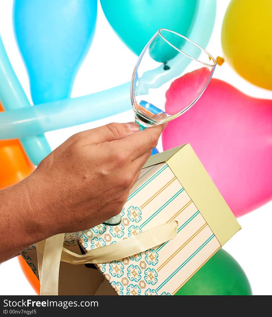 A hand holding a wineglass over the balloons. A hand holding a wineglass over the balloons