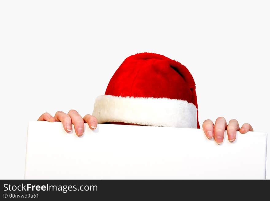 Beautiful girl in christmas bikini and with christmas hat is holding up a white sign for copy space. With background clipping path for your convenience. Beautiful girl in christmas bikini and with christmas hat is holding up a white sign for copy space. With background clipping path for your convenience