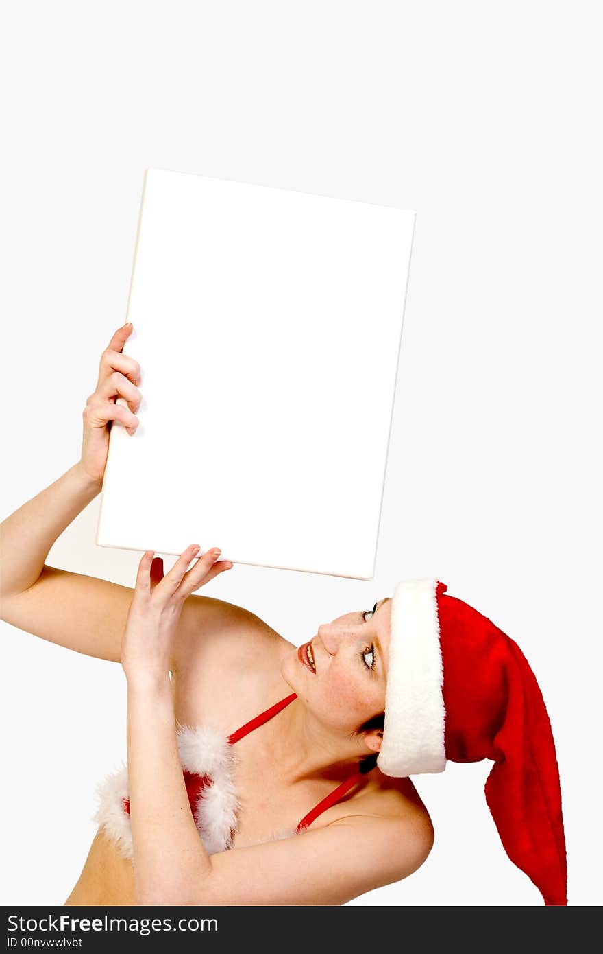 Beautiful girl in christmas bikini and with christmas hat is holding up a white sign for copy space. With background clipping path for your convenience. Beautiful girl in christmas bikini and with christmas hat is holding up a white sign for copy space. With background clipping path for your convenience