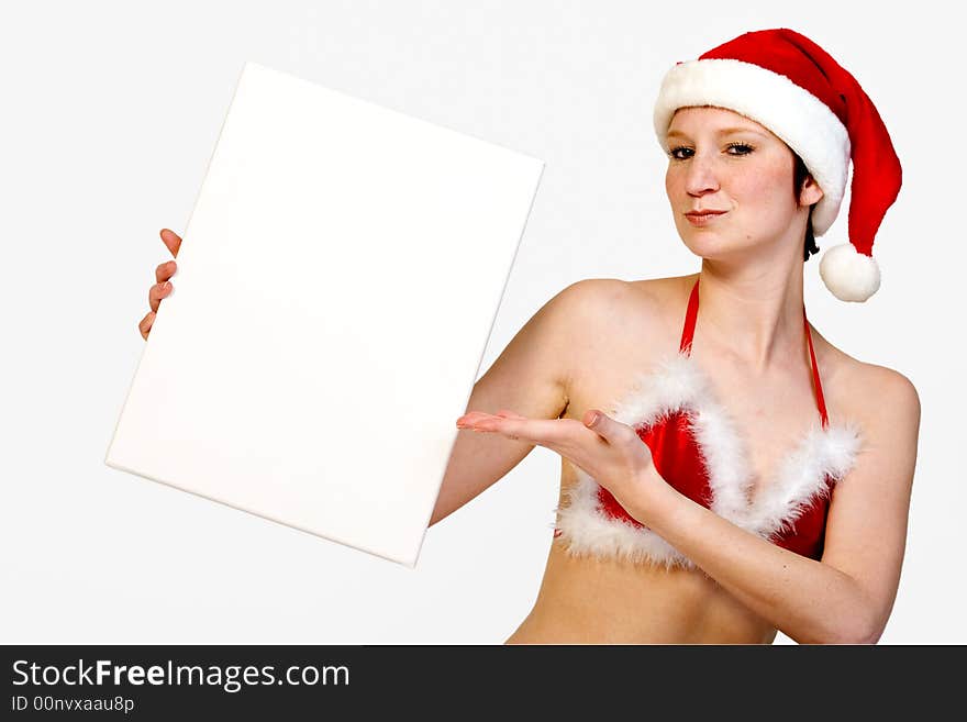 Beautiful girl in christmas bikini and with christmas hat is holding up a white sign for copy space. With background clipping path for your convenience. Beautiful girl in christmas bikini and with christmas hat is holding up a white sign for copy space. With background clipping path for your convenience