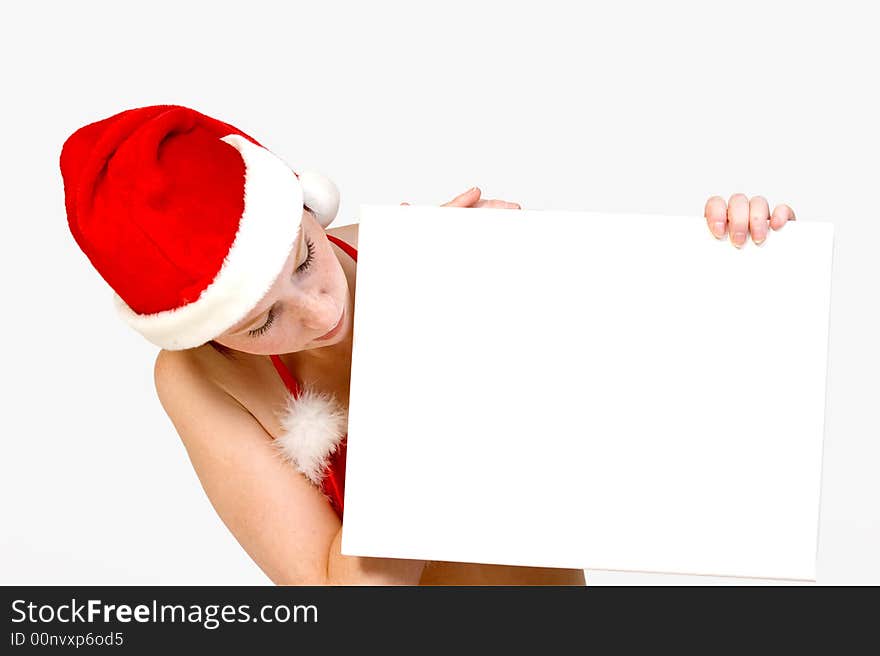 Beautiful girl in christmas bikini and with christmas hat is holding up a white sign for copy space. With background clipping path for your convenience. Beautiful girl in christmas bikini and with christmas hat is holding up a white sign for copy space. With background clipping path for your convenience