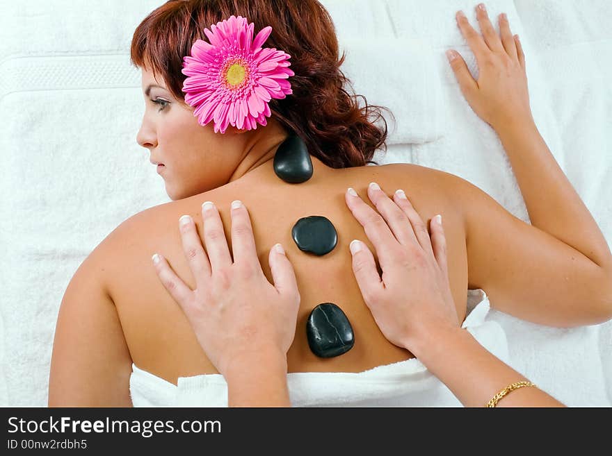 Young woman relaxing in spa salon with hot stones. Young woman relaxing in spa salon with hot stones