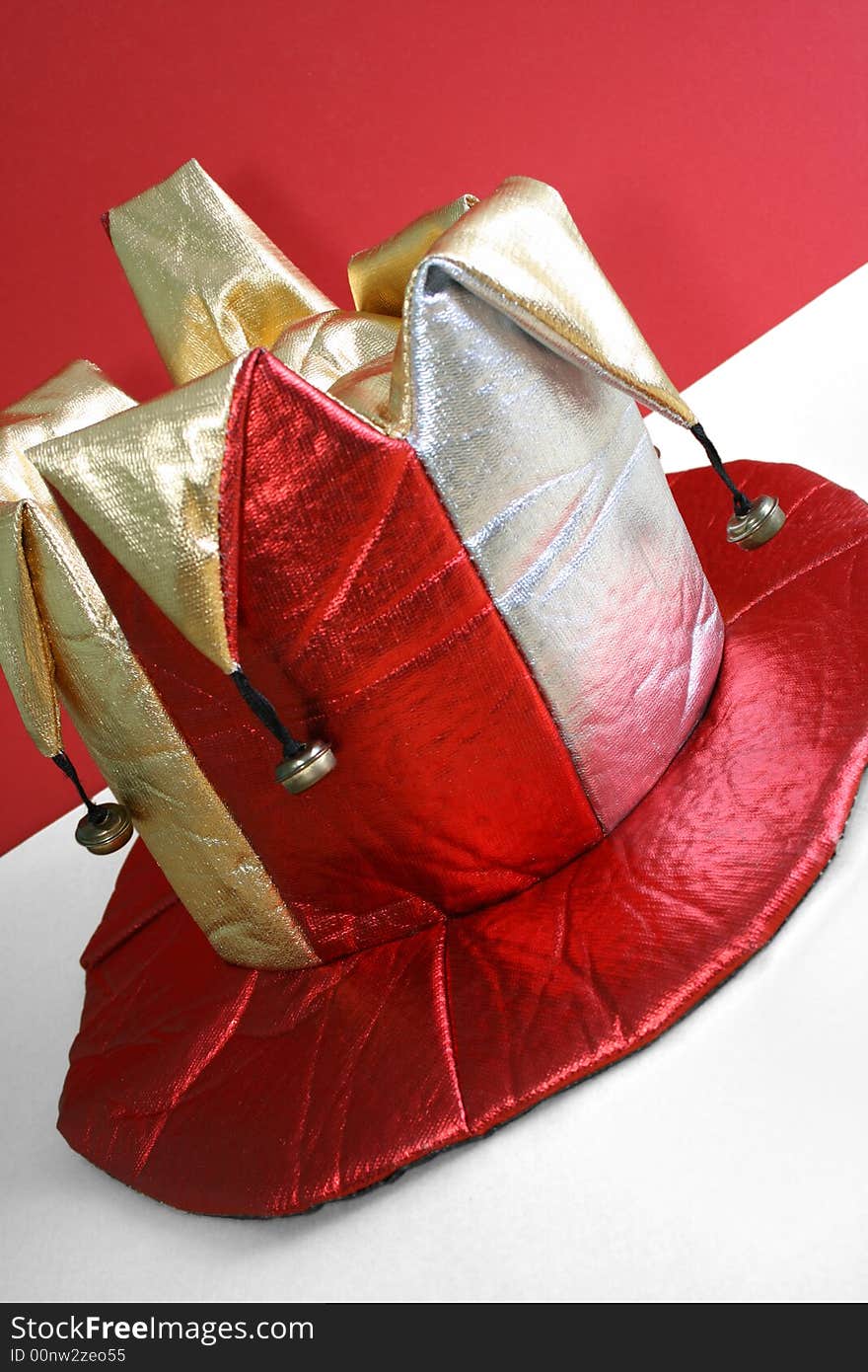 Fun hat worn by a jester against the red background. Fun hat worn by a jester against the red background