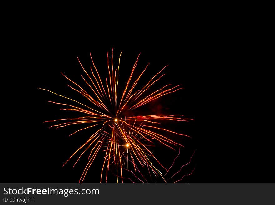 Red, white, yellow fireworks over dark sky