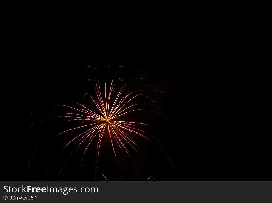 Red, white, fireworks over dark sky