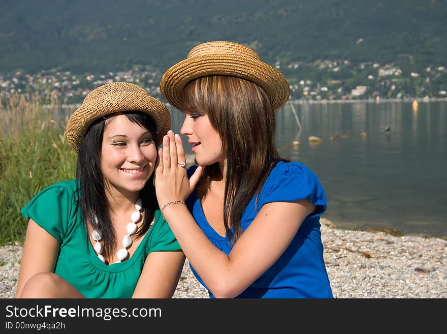 Woman speaking in the ear of another woman. Woman speaking in the ear of another woman