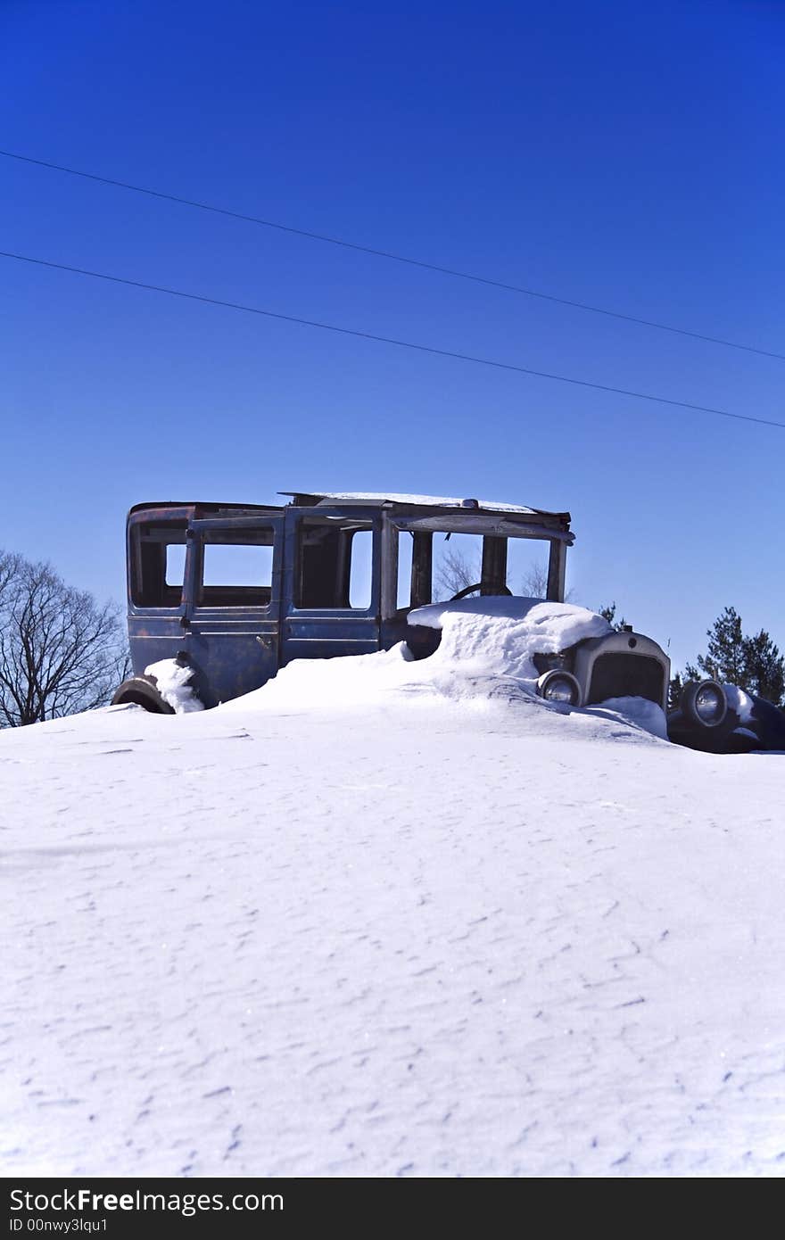 Old car in a snow & blue sky