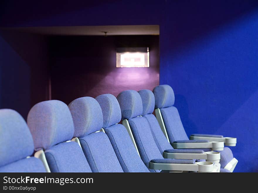 Empty cinema auditorium with blue chairs