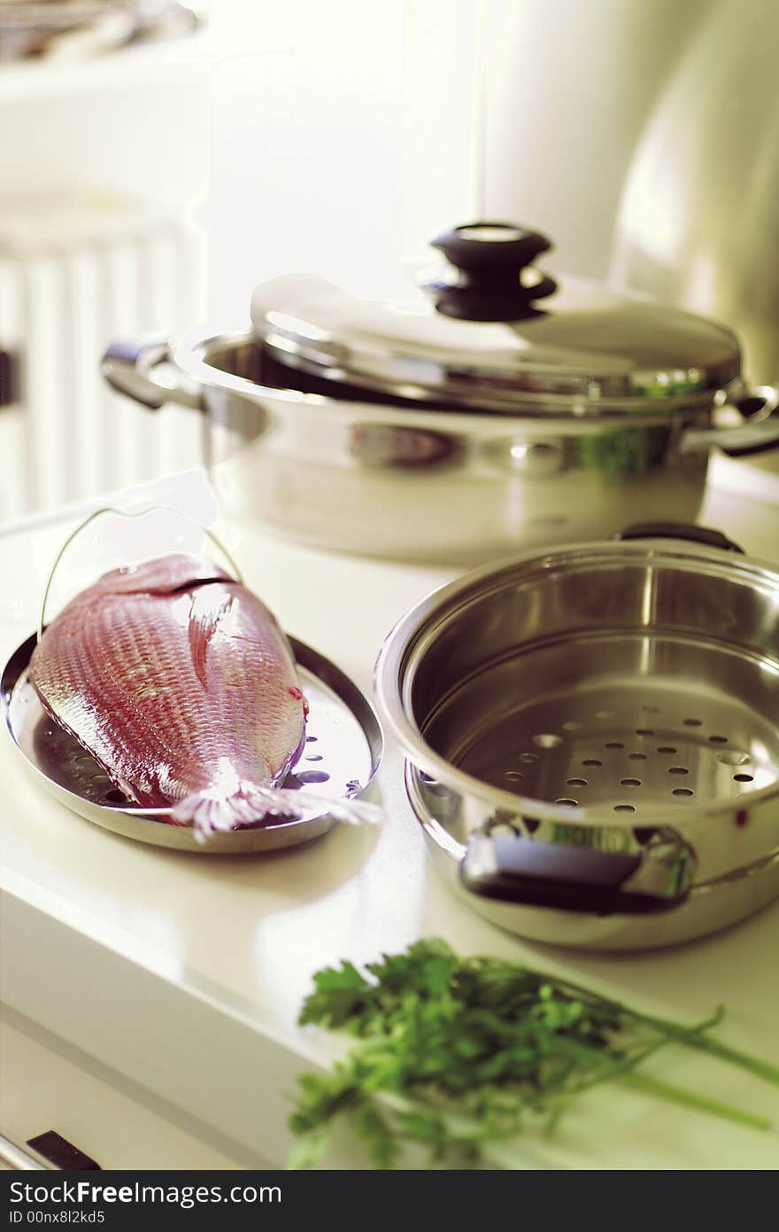 Country Kitchen, preparing a meal with fish in stainless steel pot. Country Kitchen, preparing a meal with fish in stainless steel pot