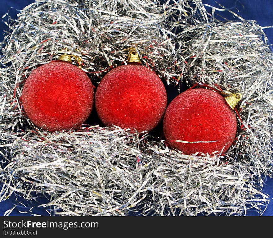 Three red xmas decorations on tinsel. Three red xmas decorations on tinsel.