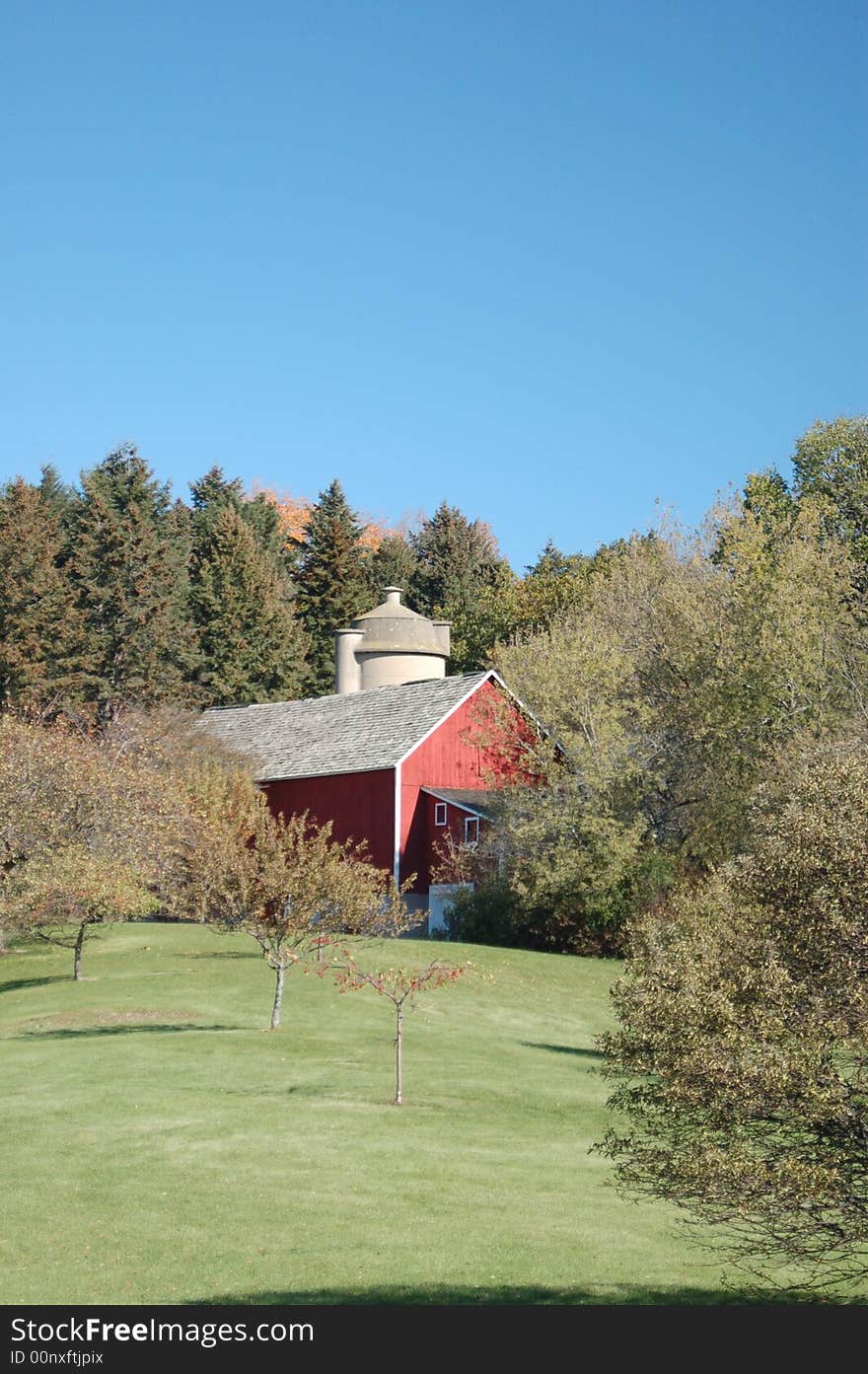 Red barn set on a holling hill with autumn fall foliage. Red barn set on a holling hill with autumn fall foliage