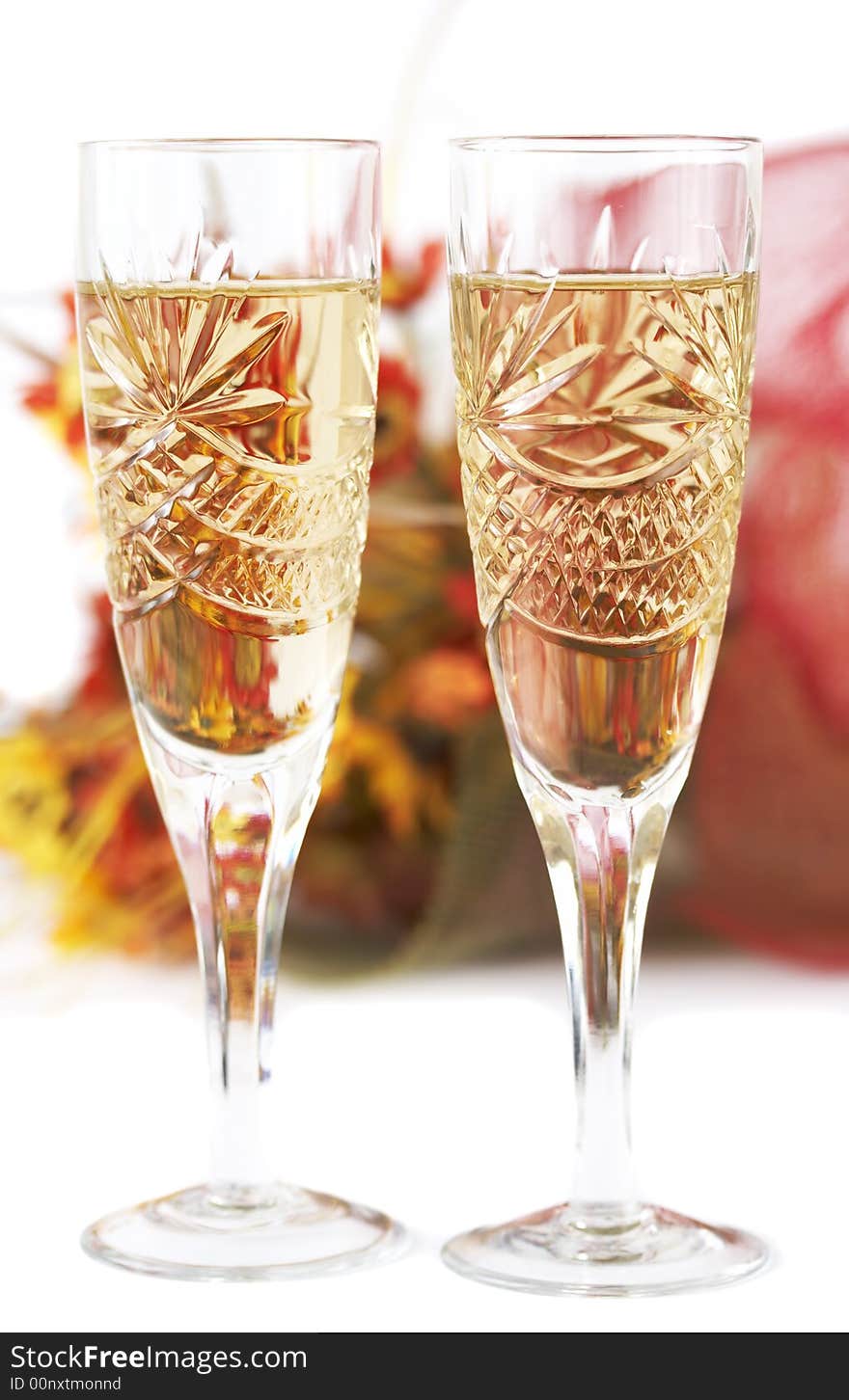 Two wineglasses with flowers as background