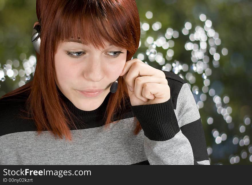 Young friendly call center girl helping on a handset.

Studio shot.