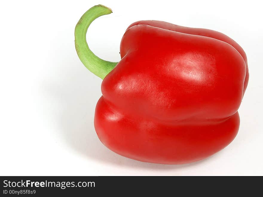 Isolated nice big red paprika with green tail against white. Isolated nice big red paprika with green tail against white