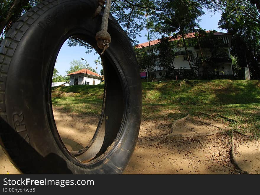 Tyre swing and old house surround by the tree