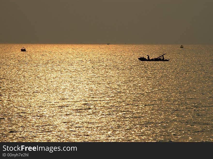 Sunset at sea with shipping boat silhouette,Clinquant.