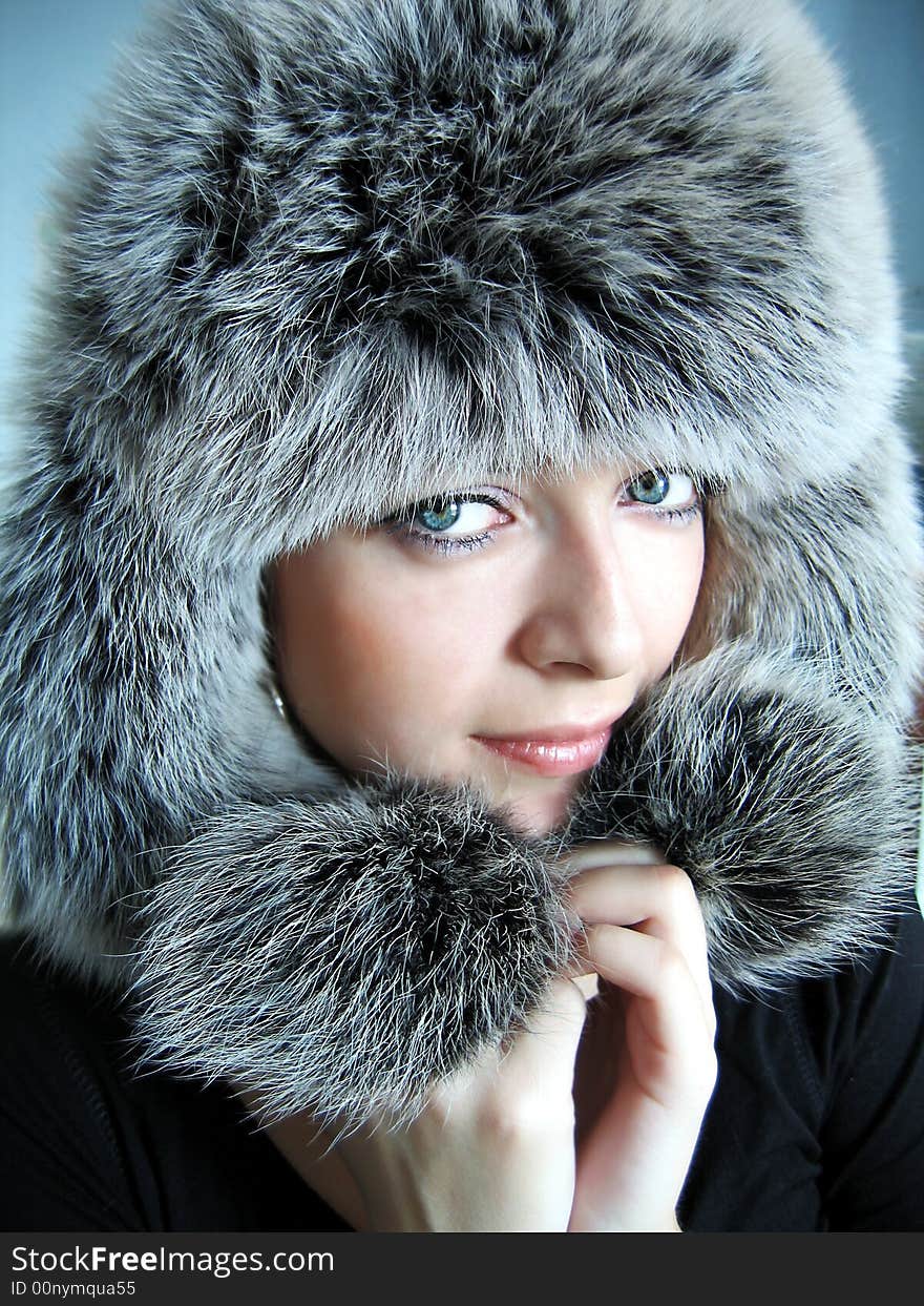 Beautiful girl in fur cap and blue eyes. Beautiful girl in fur cap and blue eyes