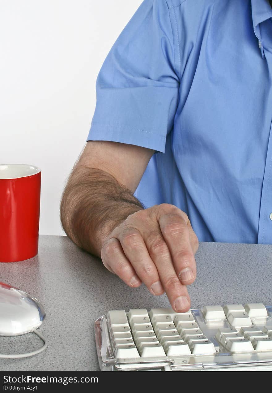 Man seated at desk using computer keyboard. Man seated at desk using computer keyboard.