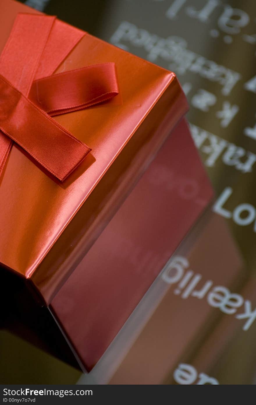 Bright red box over a glass with the word love in different languages. Bright red box over a glass with the word love in different languages