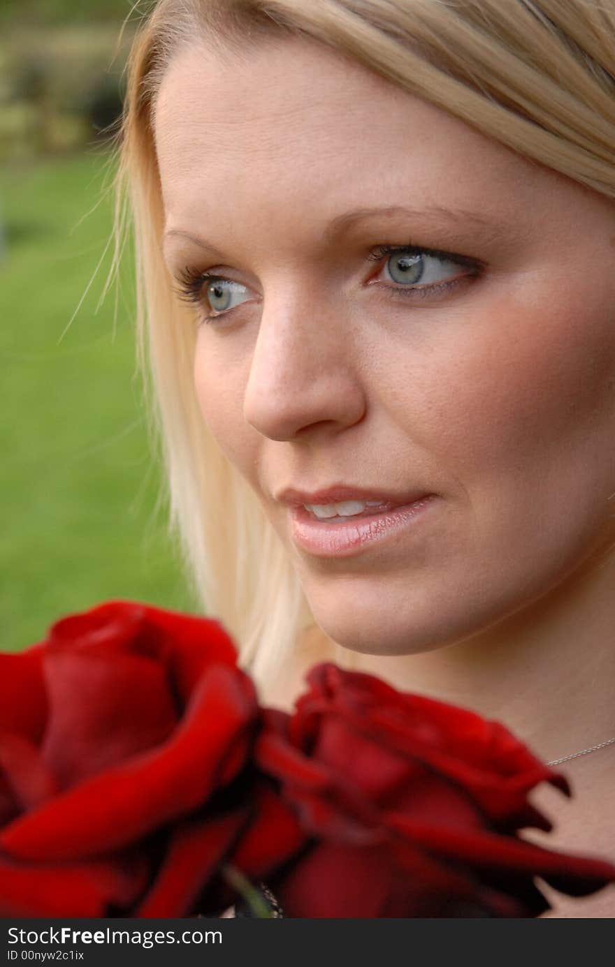 Portrait of blonde woman holding red roses. Portrait of blonde woman holding red roses.