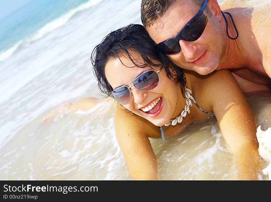 A portrait of attractive couple having fun on the beach. A portrait of attractive couple having fun on the beach