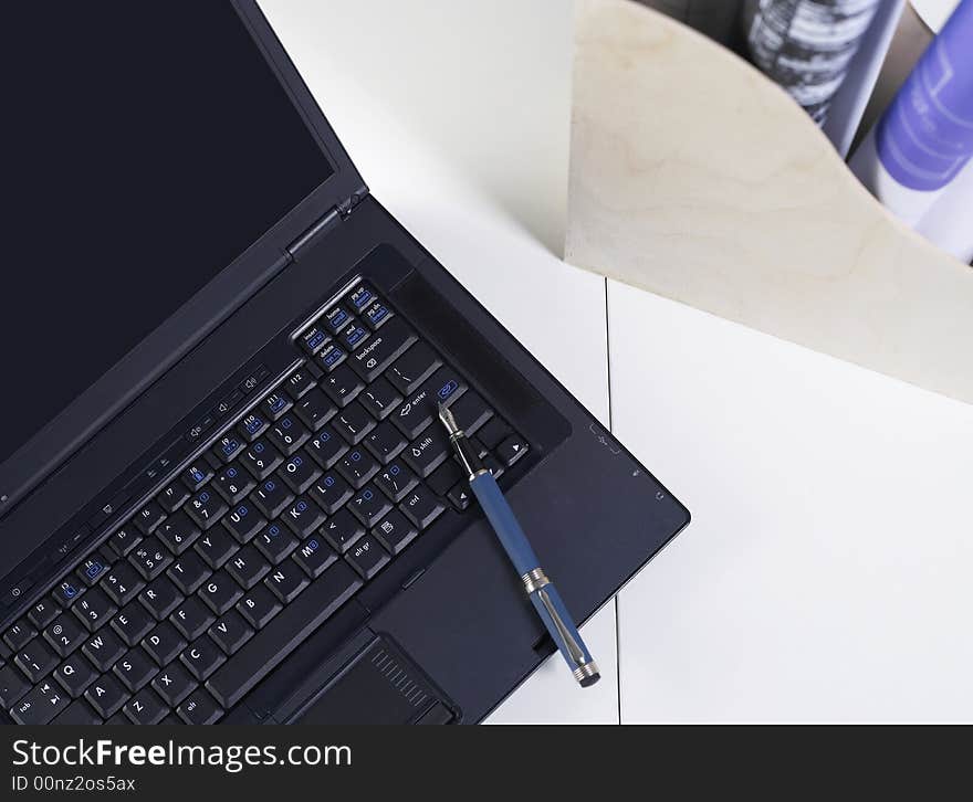 Office interior with blueprints and pen on the laptop. Office interior with blueprints and pen on the laptop