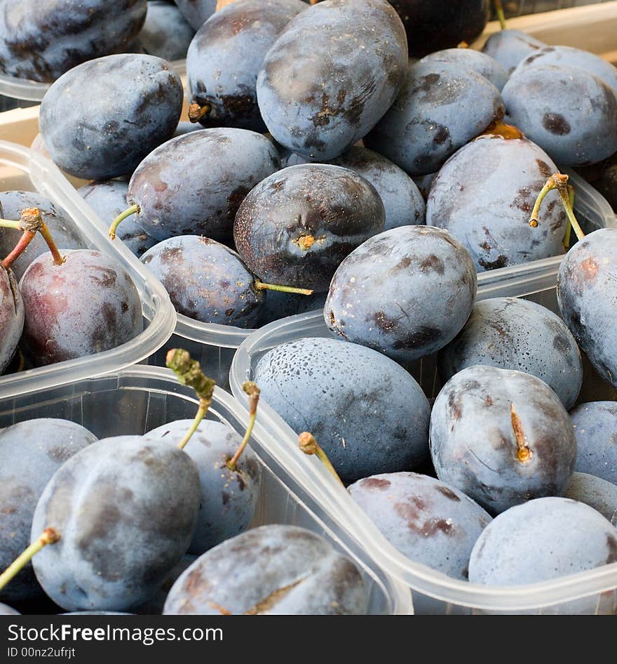 A fruit stand with plums for sale.