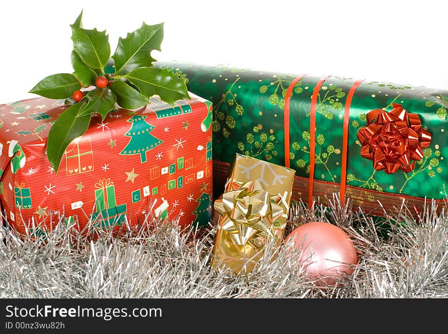 Christmas gifts, presents, wrapped with decorative stars and ribbons, ilex,holly on top of it. Christmas gifts, presents, wrapped with decorative stars and ribbons, ilex,holly on top of it