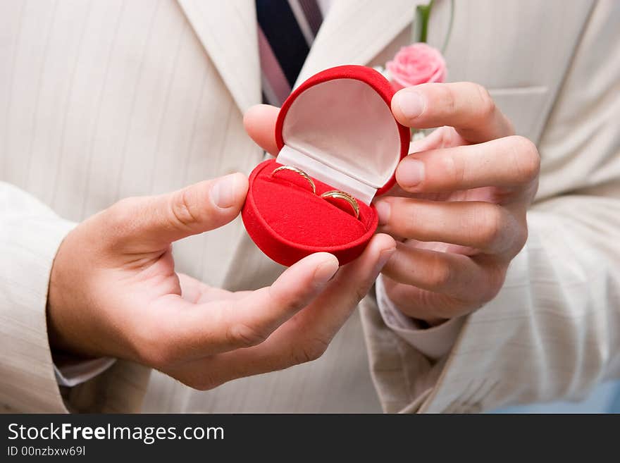 Box With Golden Rings In Hands