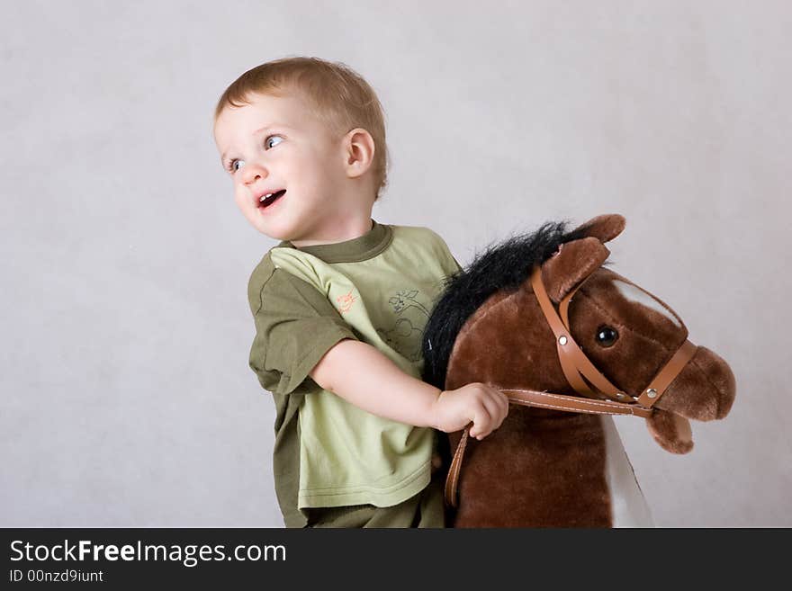Laughing boy sitting on a toy horse