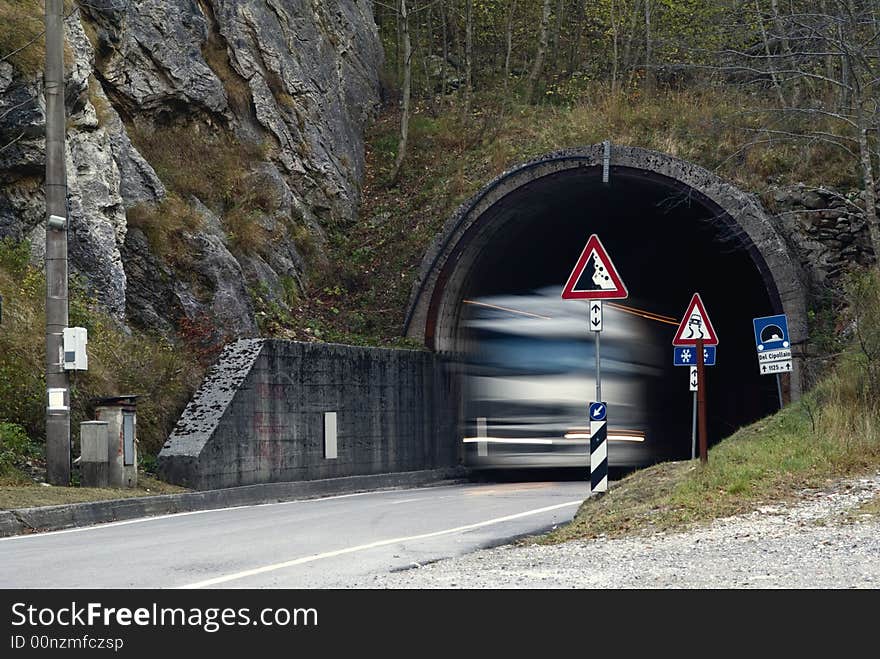 Big  motion blurred truck come out of a gallery in the alps. Big  motion blurred truck come out of a gallery in the alps