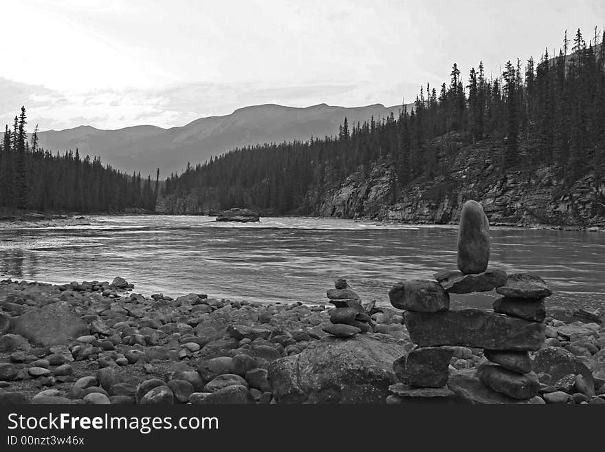 Rock figures against a river in black & white.