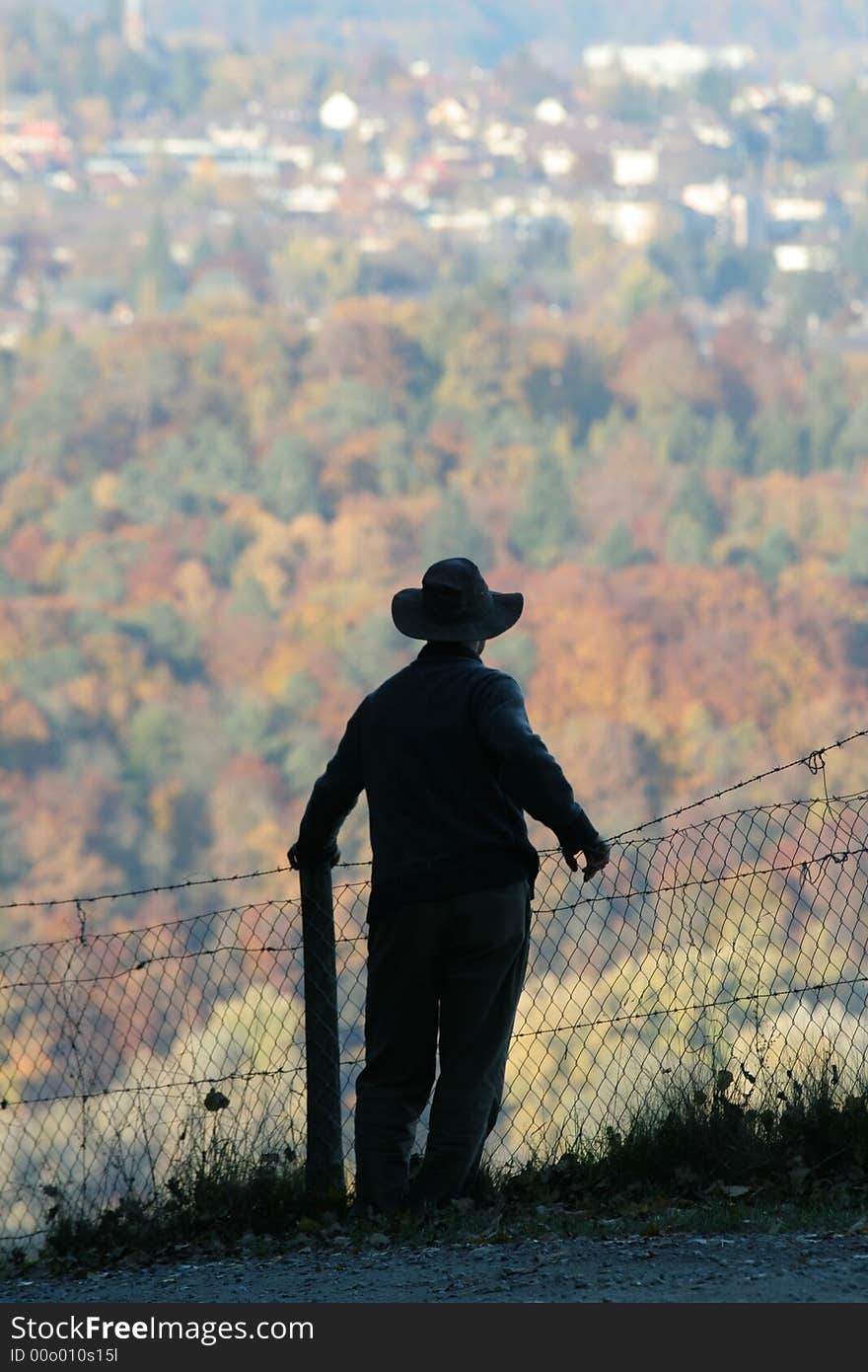 Silhouette of a man contemplating a forest and encroaching development, in Fall. Silhouette of a man contemplating a forest and encroaching development, in Fall.