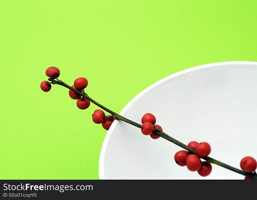 Bunch of red fruit of berry in the bowl on green background. Bunch of red fruit of berry in the bowl on green background