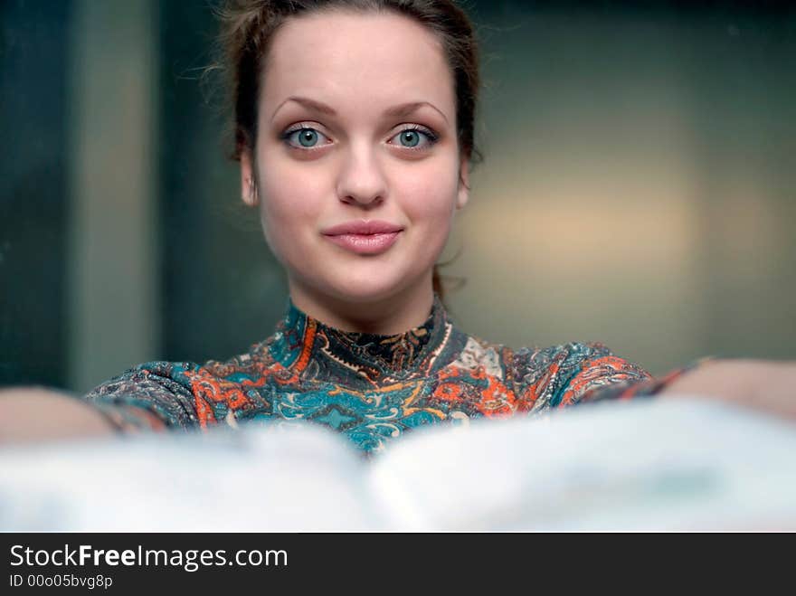 Portrait of young woman with opened book in hands. Portrait of young woman with opened book in hands