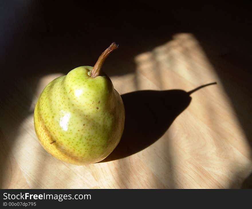 Green pear close-up shot with sunlight and shadow