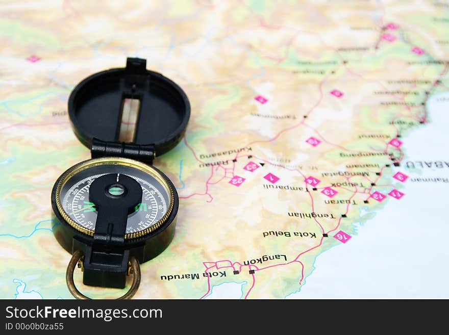 A navigational compass laid on a map.