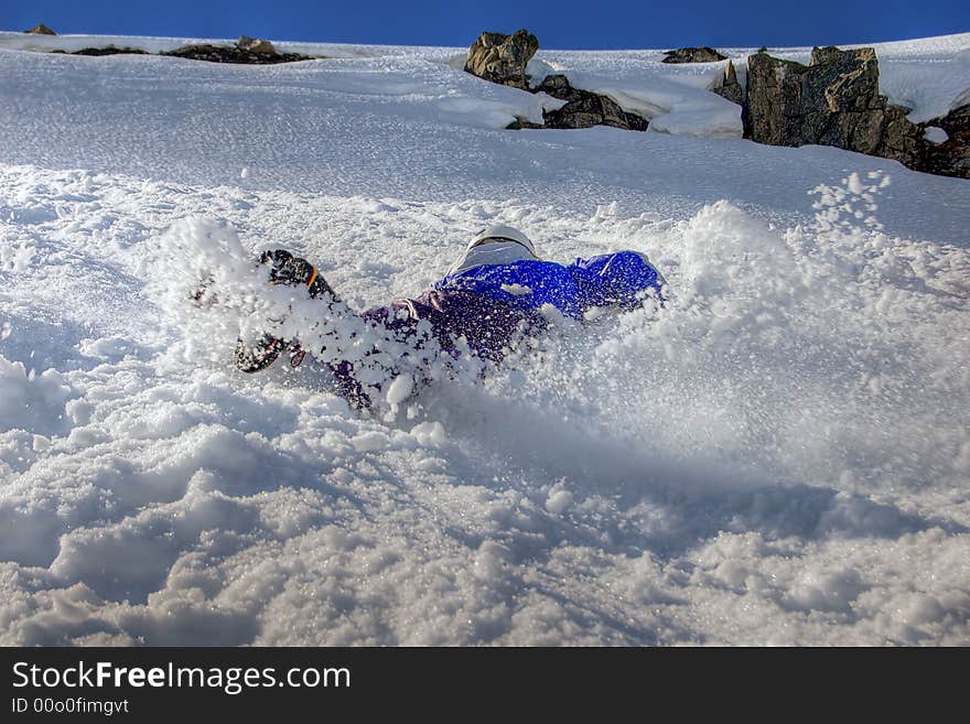 A man sliding on a snow-covered slope. A man sliding on a snow-covered slope.