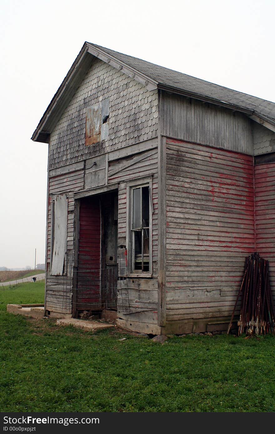 An old one room school house in a field on a cloudy day. An old one room school house in a field on a cloudy day.