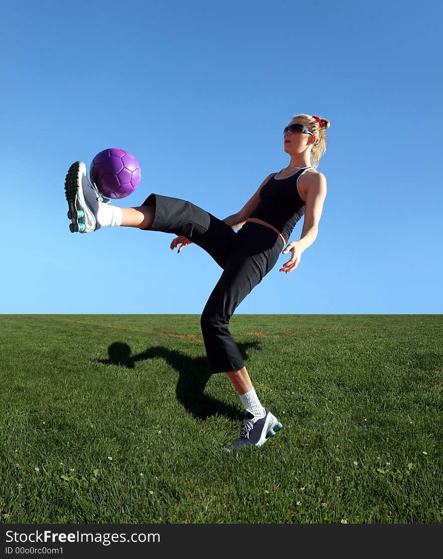 Young woman exercising with the ball in a park