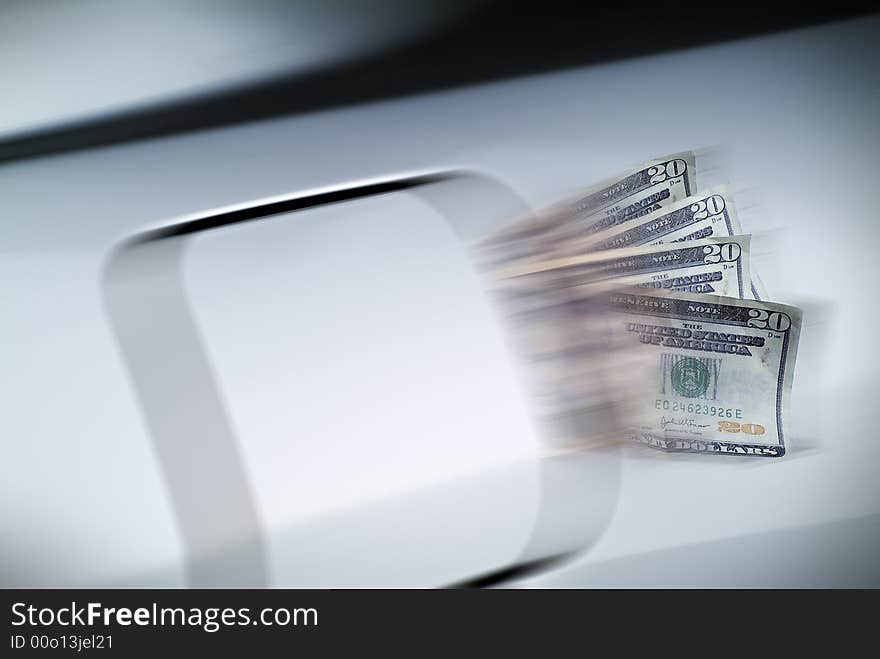 Motion blur of money spilling from a fuel filler door while car is in motion. Motion blur of money spilling from a fuel filler door while car is in motion.