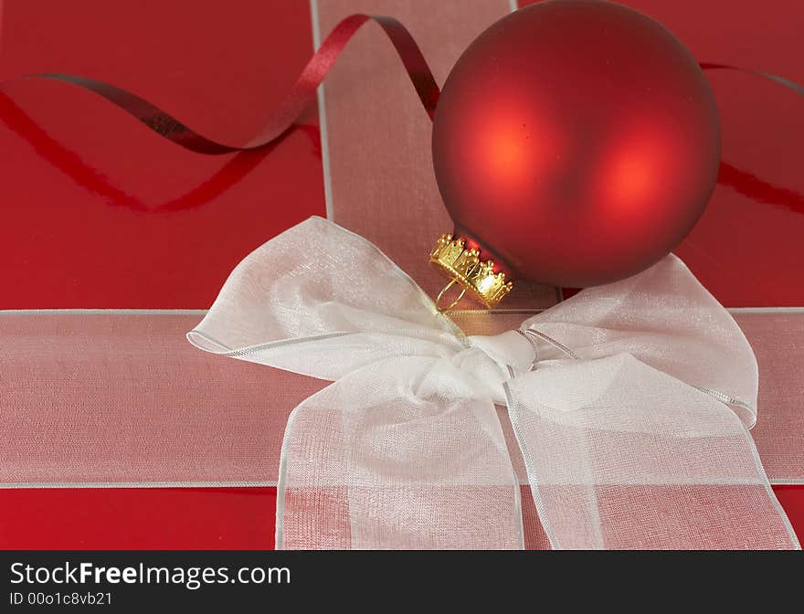 A red box and white ribbon holiday present. A red box and white ribbon holiday present